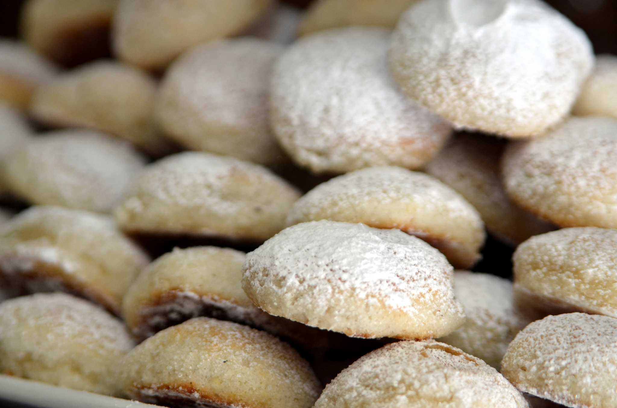A pile of round sugar-dusted genovese ericina pastries.