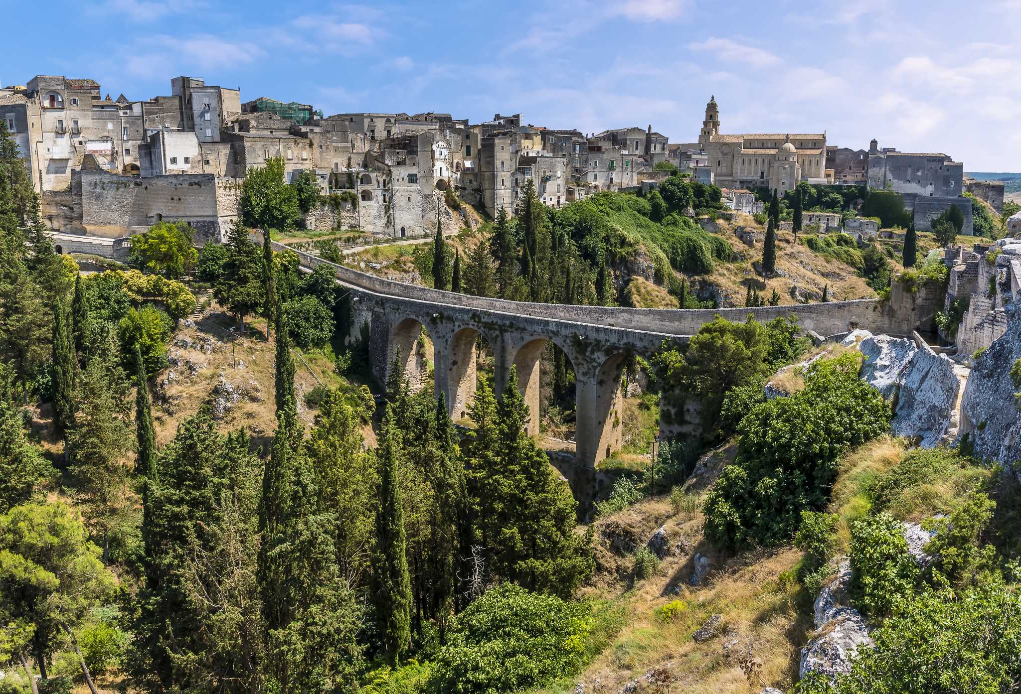 Stone aqueduct bridge over the ravine at Gravina in Puglia, with the old town above.