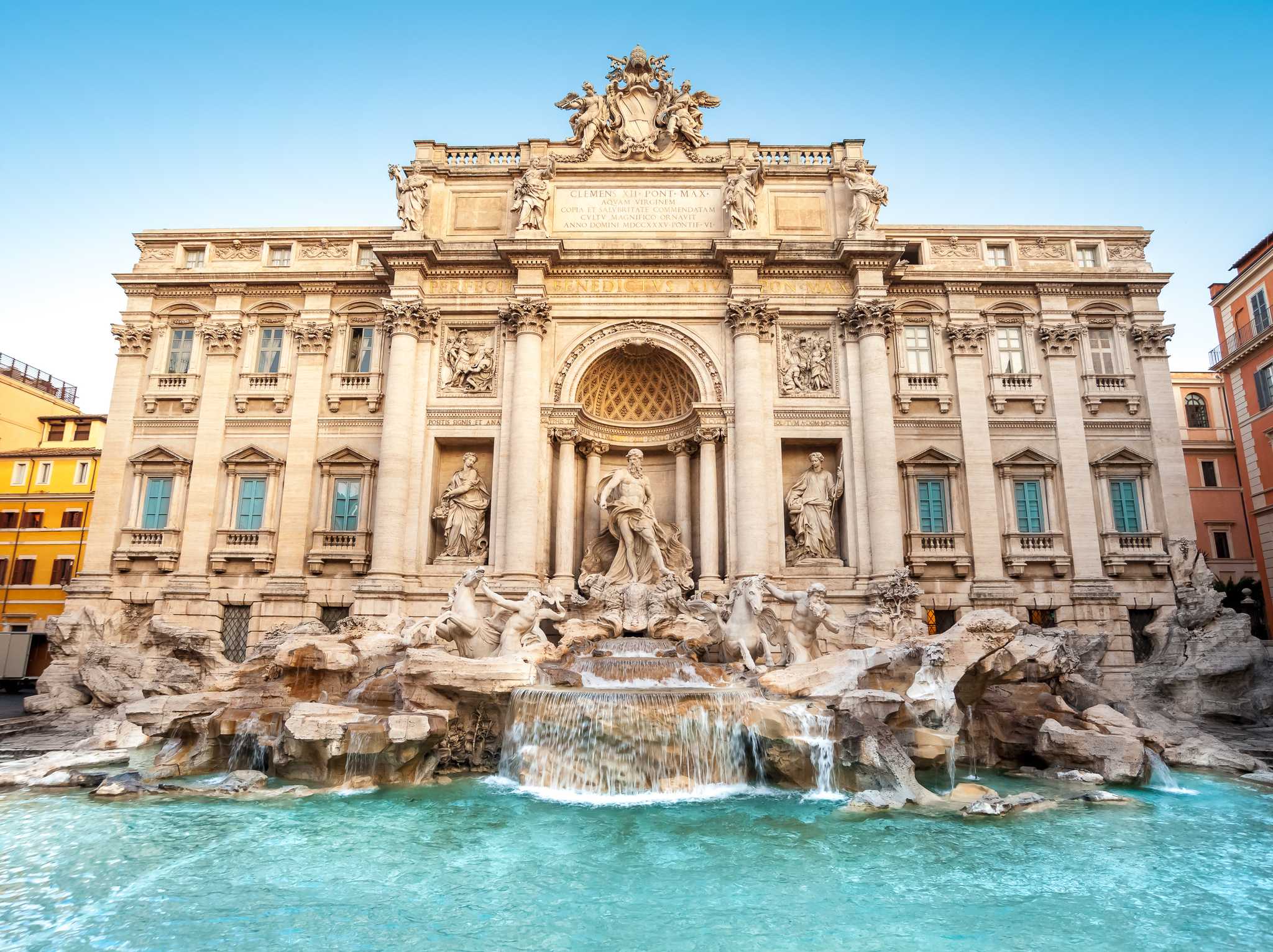 The Trevi Fountain's marble figures and falling water above a turquoise basin.