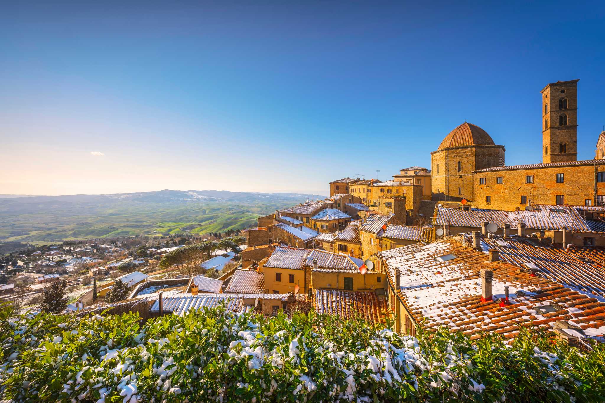 Snow on the rooftops and cathedral of the Tuscan hill town of Volterra.
