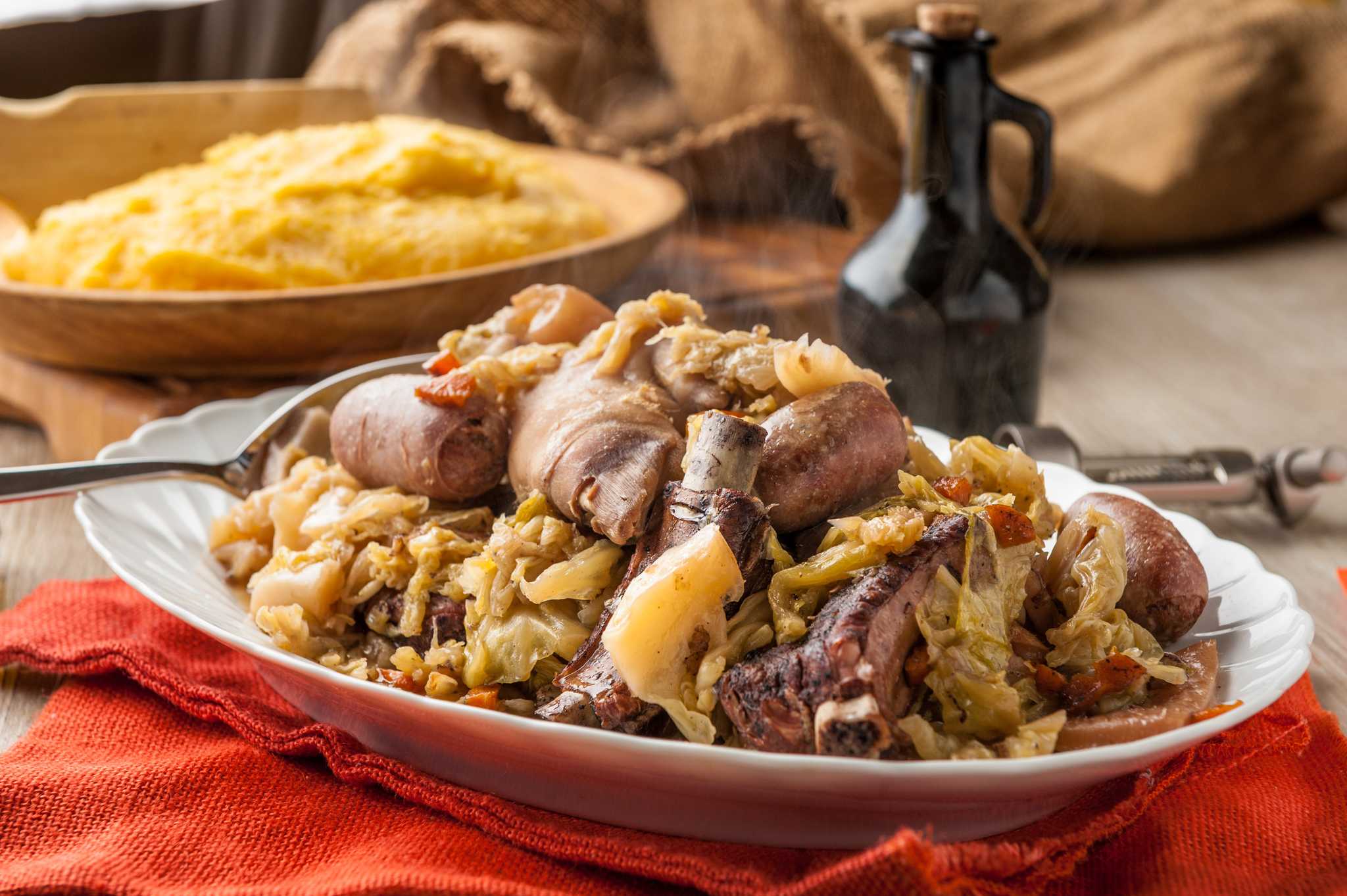 Cassoeula of pork and cabbage served with a bowl of polenta alongside.