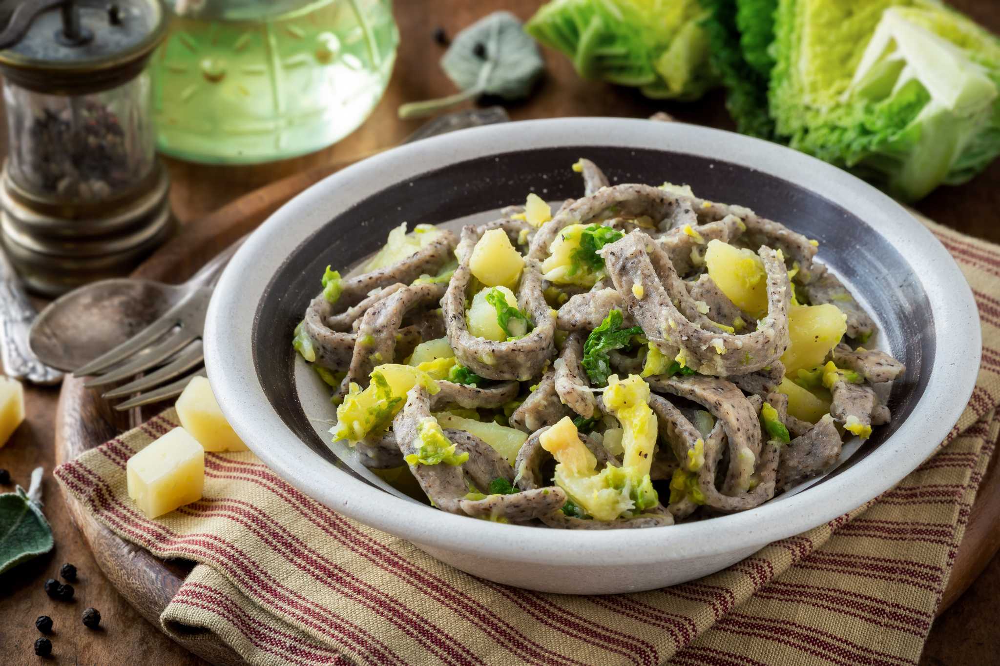 Ribbons of buckwheat pasta tossed with potato and cabbage in a rustic bowl.