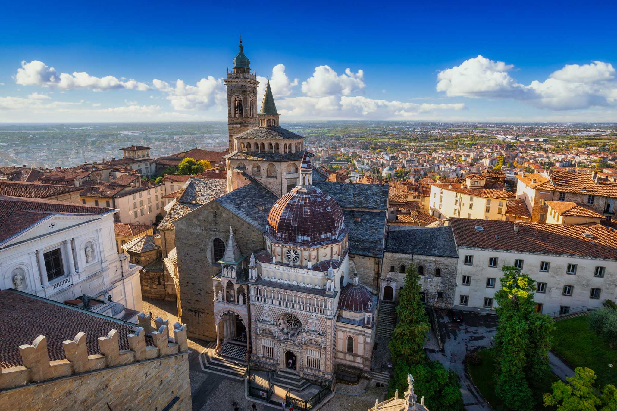 The domes and marble chapel of Bergamo's Città Alta, rising above the rooftops of the lower town.