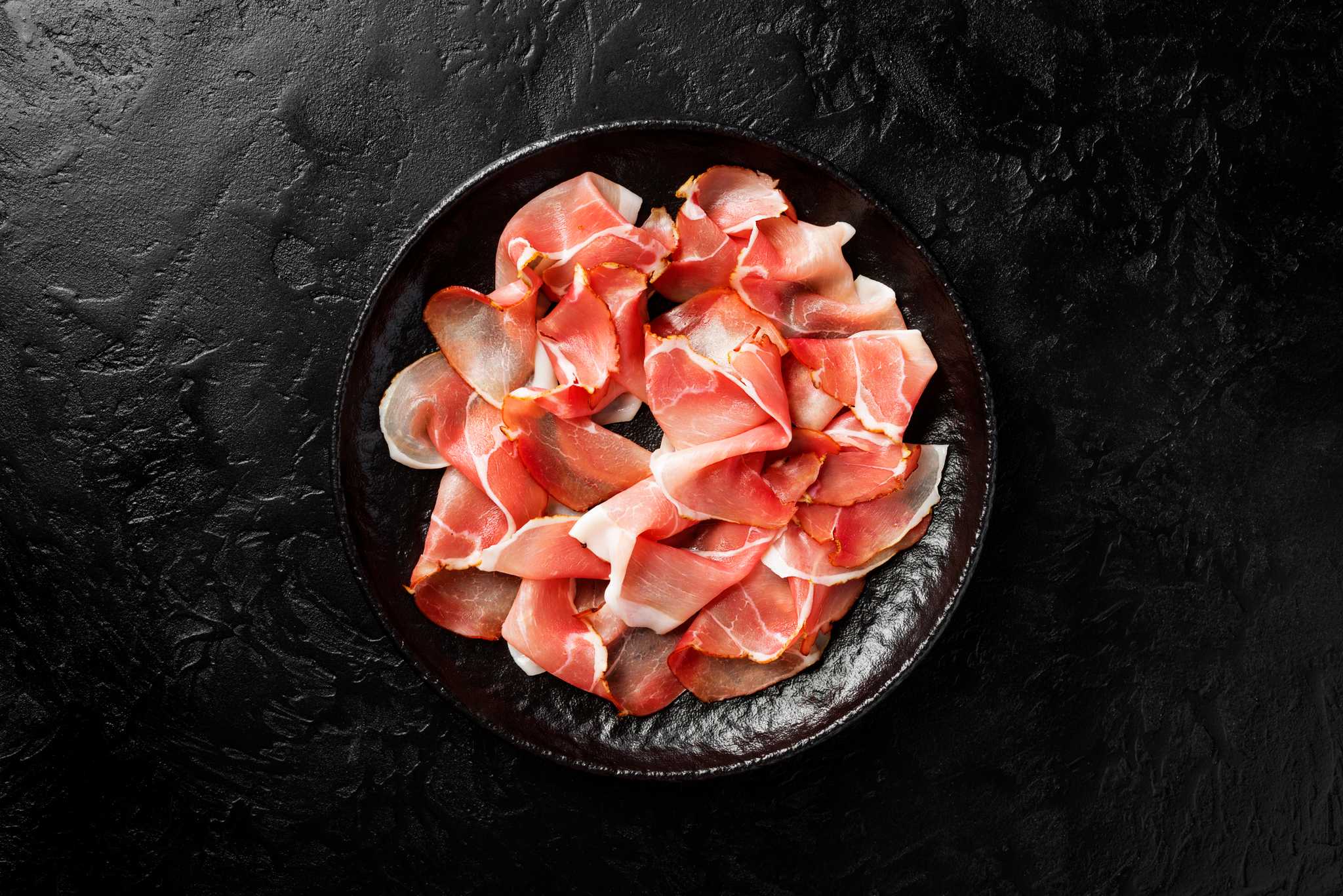 A plate of prosciutto di parma, a thinly sliced cured ham common in Emilia-Romagna.