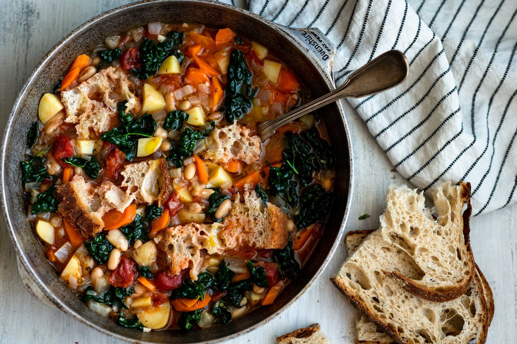 Ribollita, an Italian bread soup made of black beans and cabbage in a bowl on a table.