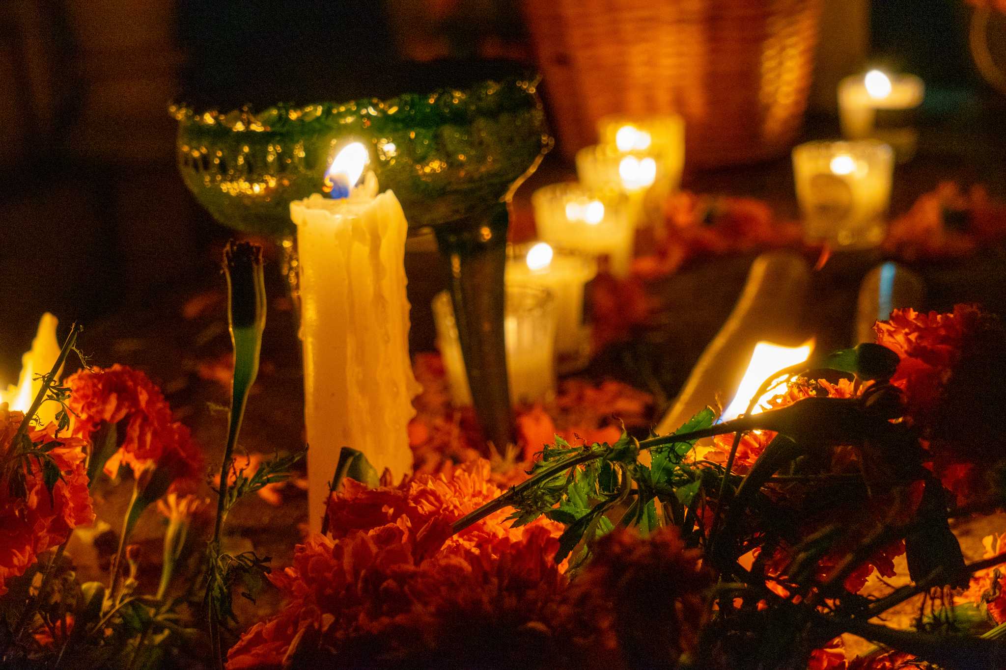 Candles, marigolds, and a green clay copal burner on a grave in Xoxocotlán, Oaxaca.