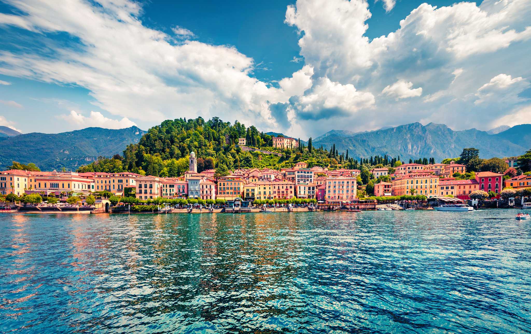 Bellagio's pastel waterfront and bell tower below a wooded hill on Lake Como.