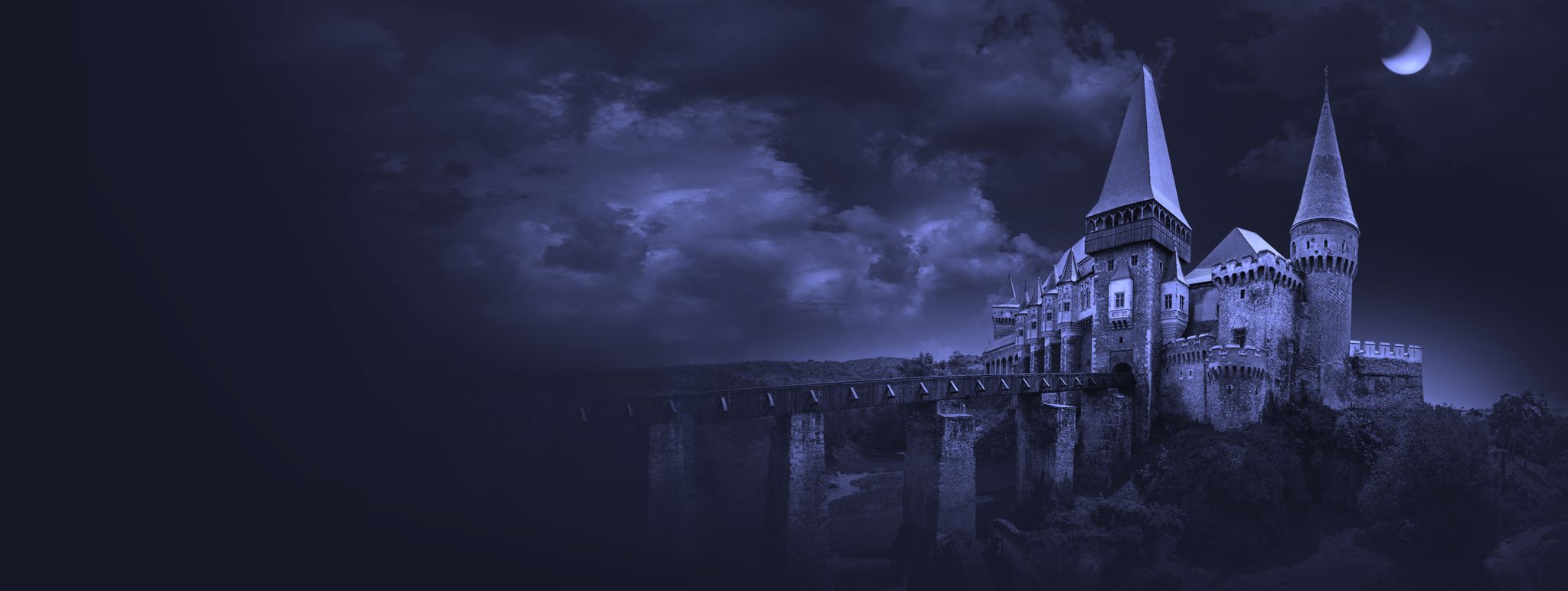Foggy, eerie, purple-hued image of Corvin Castle below a waxing moon.