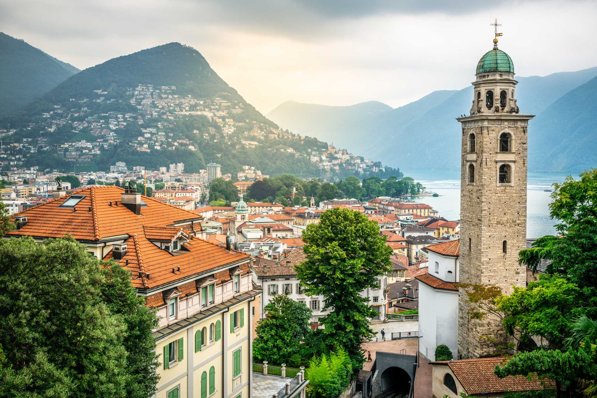 Lugano's rooftops and cathedral bell tower above the lake in Switzerland.