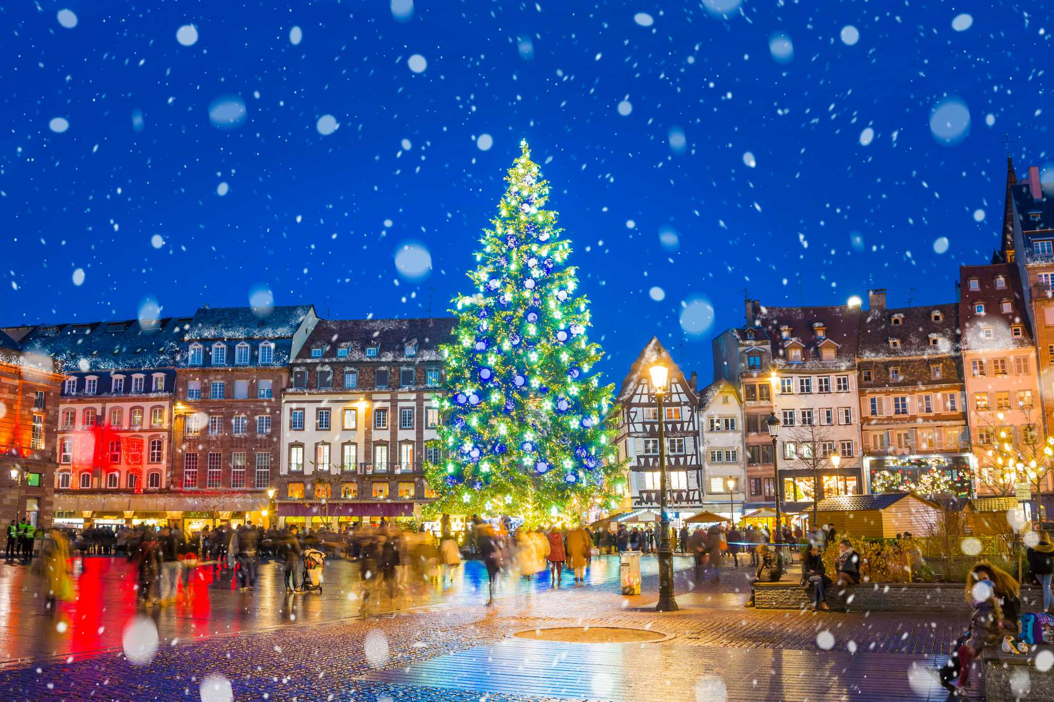 Snow falling in front of the brightly decorated Christmas tree in Kleber Square, Strasbourg.