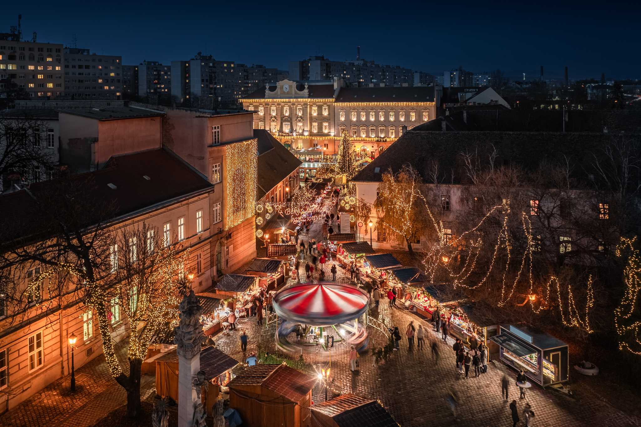 Aerial shot of Budapest’s Christmas market, a red and white carousel spinning.