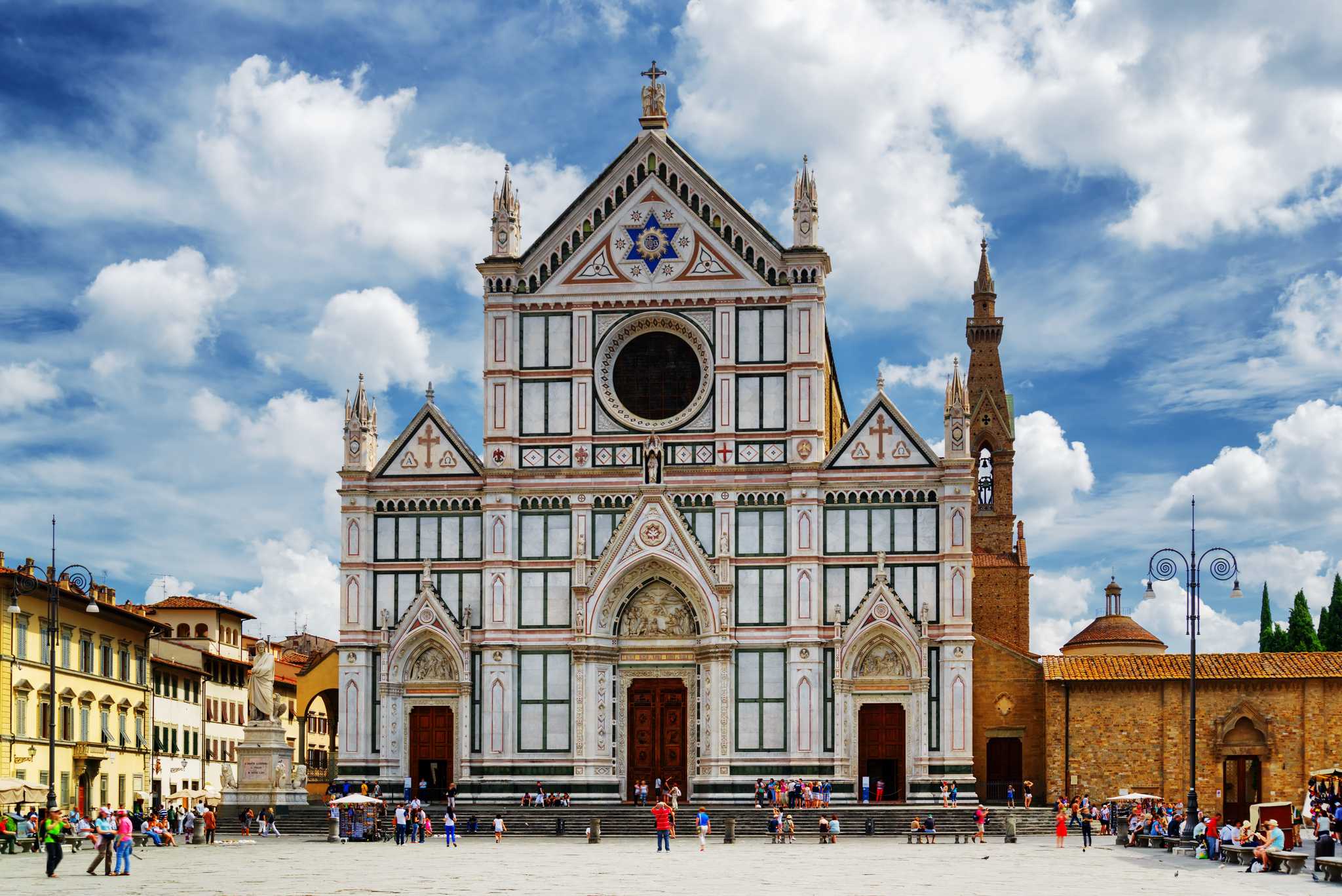Florence’s grand Franciscan Basilica during the day with people in the square.