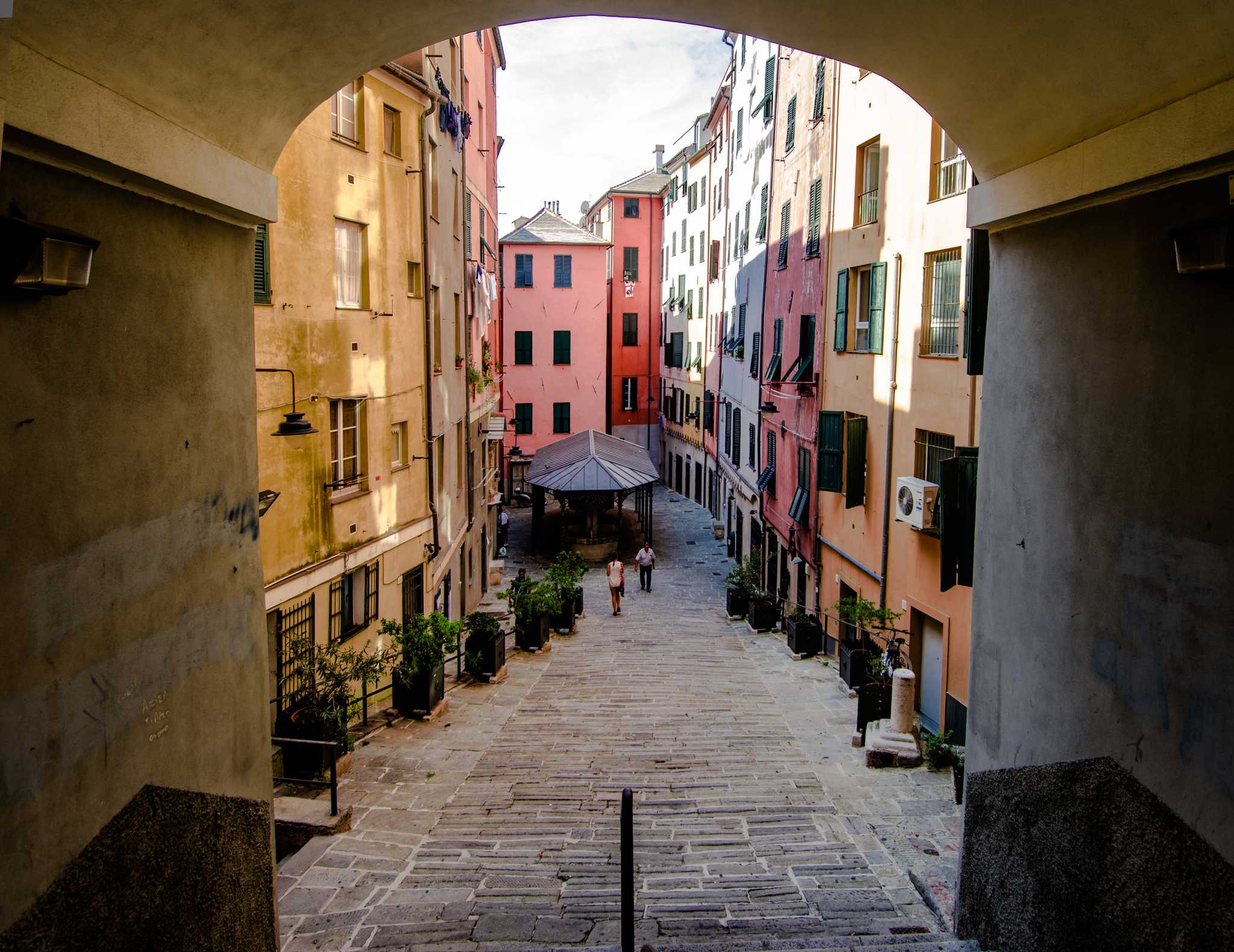 The alleys of Genoa, lined with colorful apartments and flower planters.