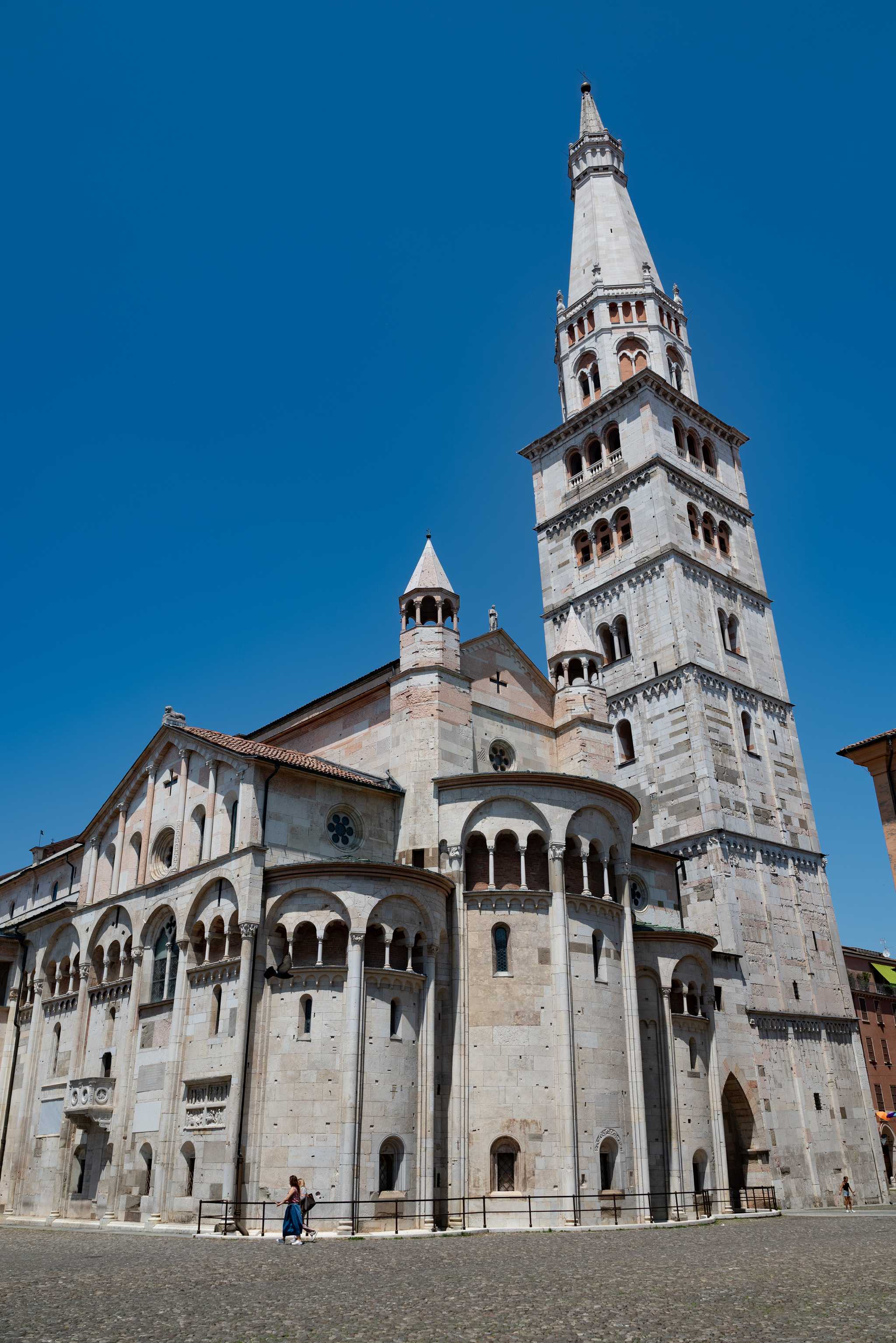 Upward shot of Modena’s Romanesque duomo from the stone street below.