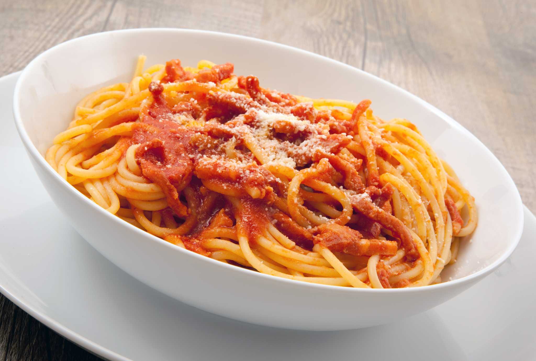 A bowl of bucatoni all'amatriciana in tomato sauce with guanciale and grated pecorino.