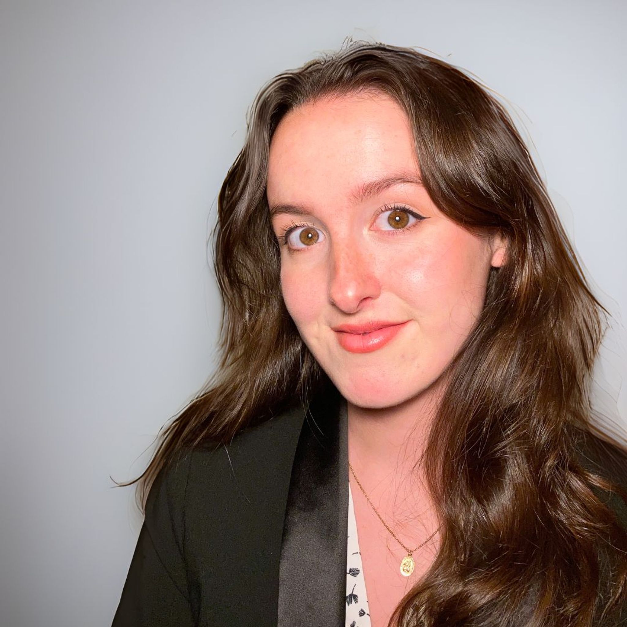 Headshot of brunette woman in blazer.