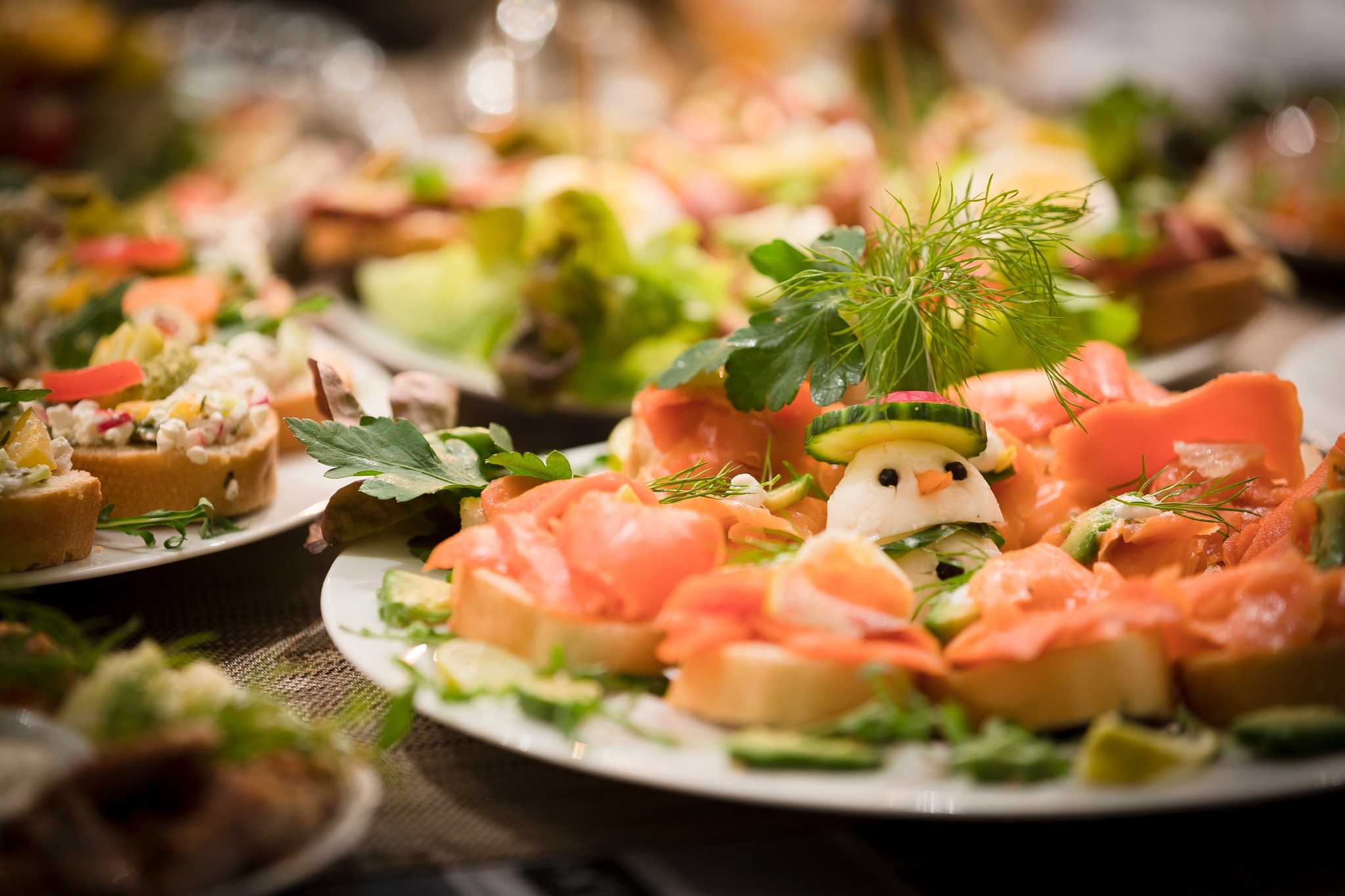 Plate of seafood-based antipasti snacks, with white cheese made into a snowman.
