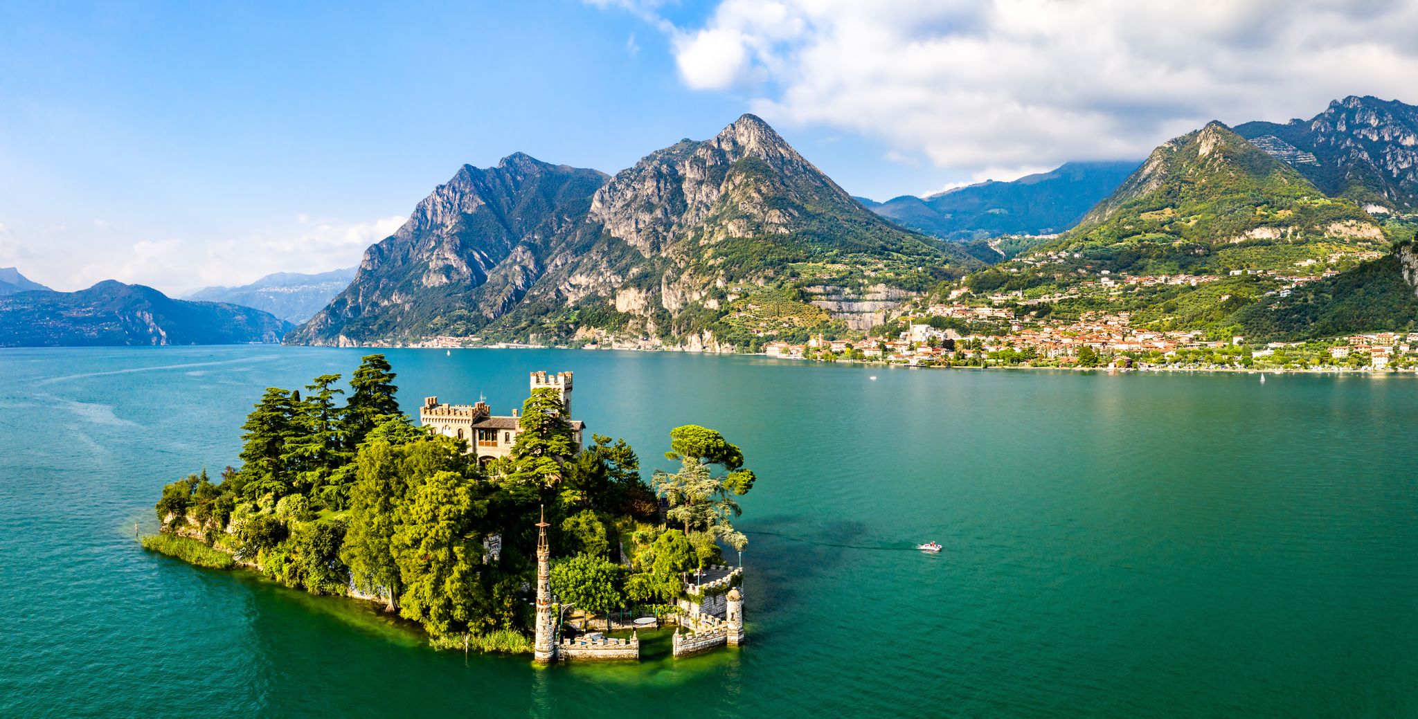 Panoramic view of Lake Iseo’s turquoise waters, mountains, and a small island.