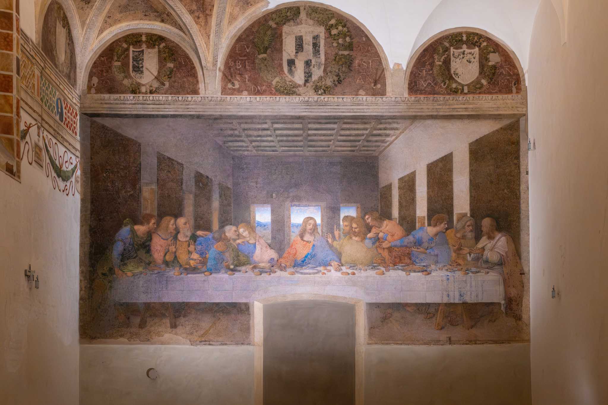 Da Vinci’s Last Supper painted on a beige wall of Santa Maria delle Grazie.