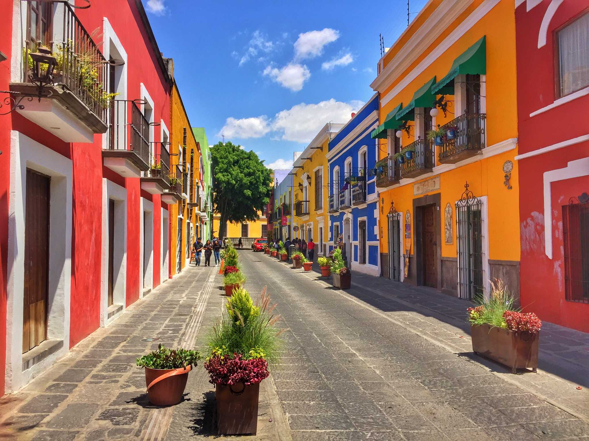 A rainbow of colonial buildings lines the street in central Puebla City, Mexico.