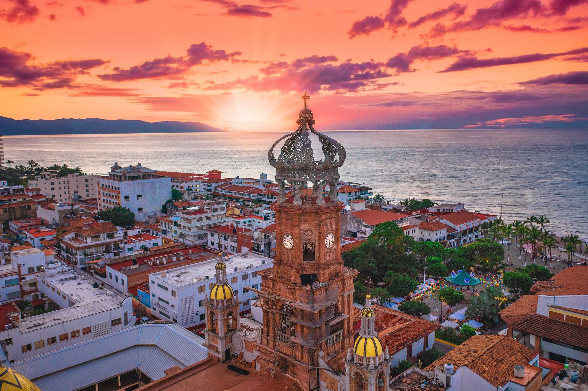 Sunset over the sea in Puerto Vallarta, with the crown-shaped tower of Our Lady of Guadalupe in the foreground.