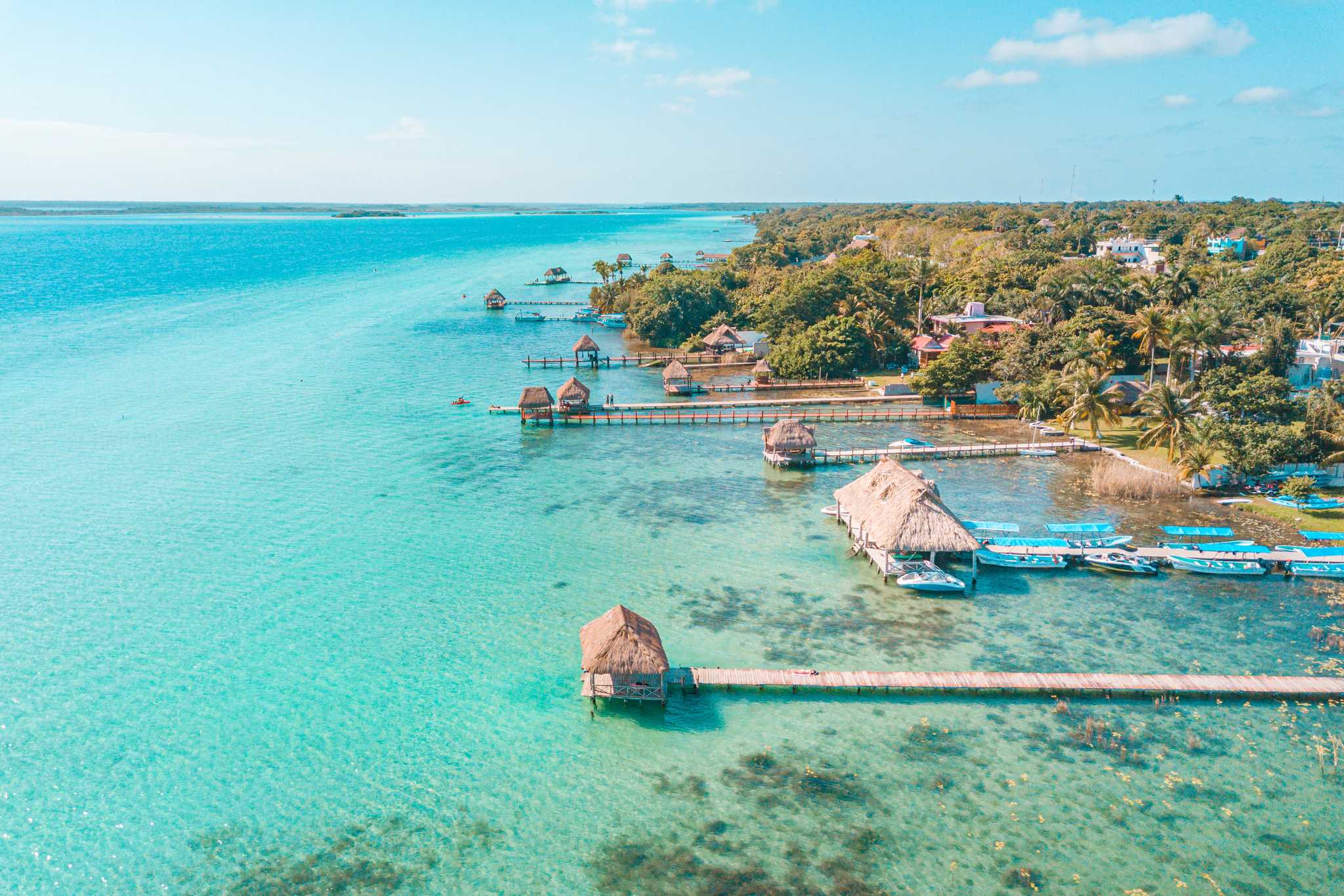 Covered docks on the bright blue waters of Bacalar Lagoon, in Mexico.