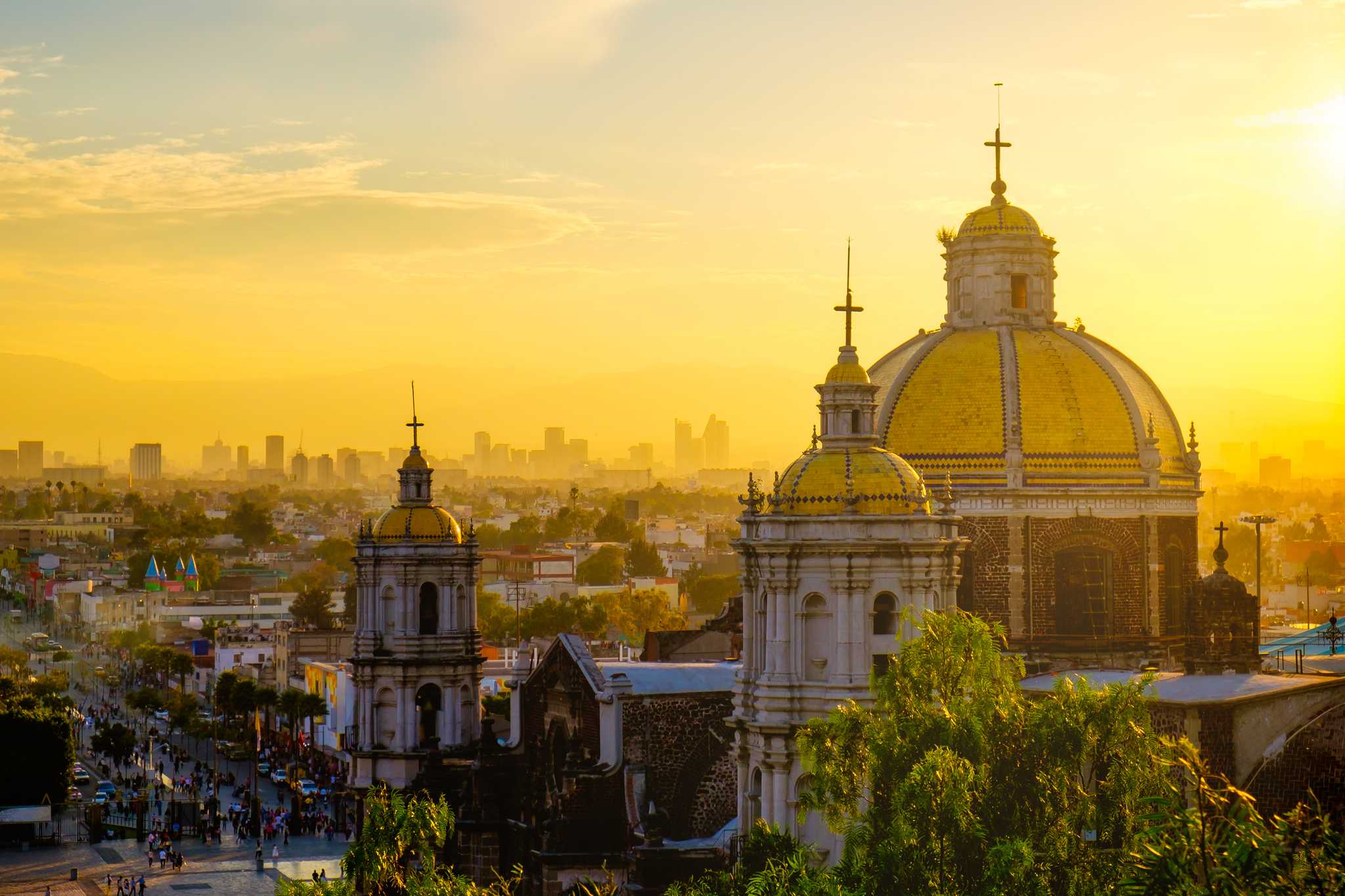Basilica of Guadalupe in Mexico City, at sunset, with the city sprawling behind it.