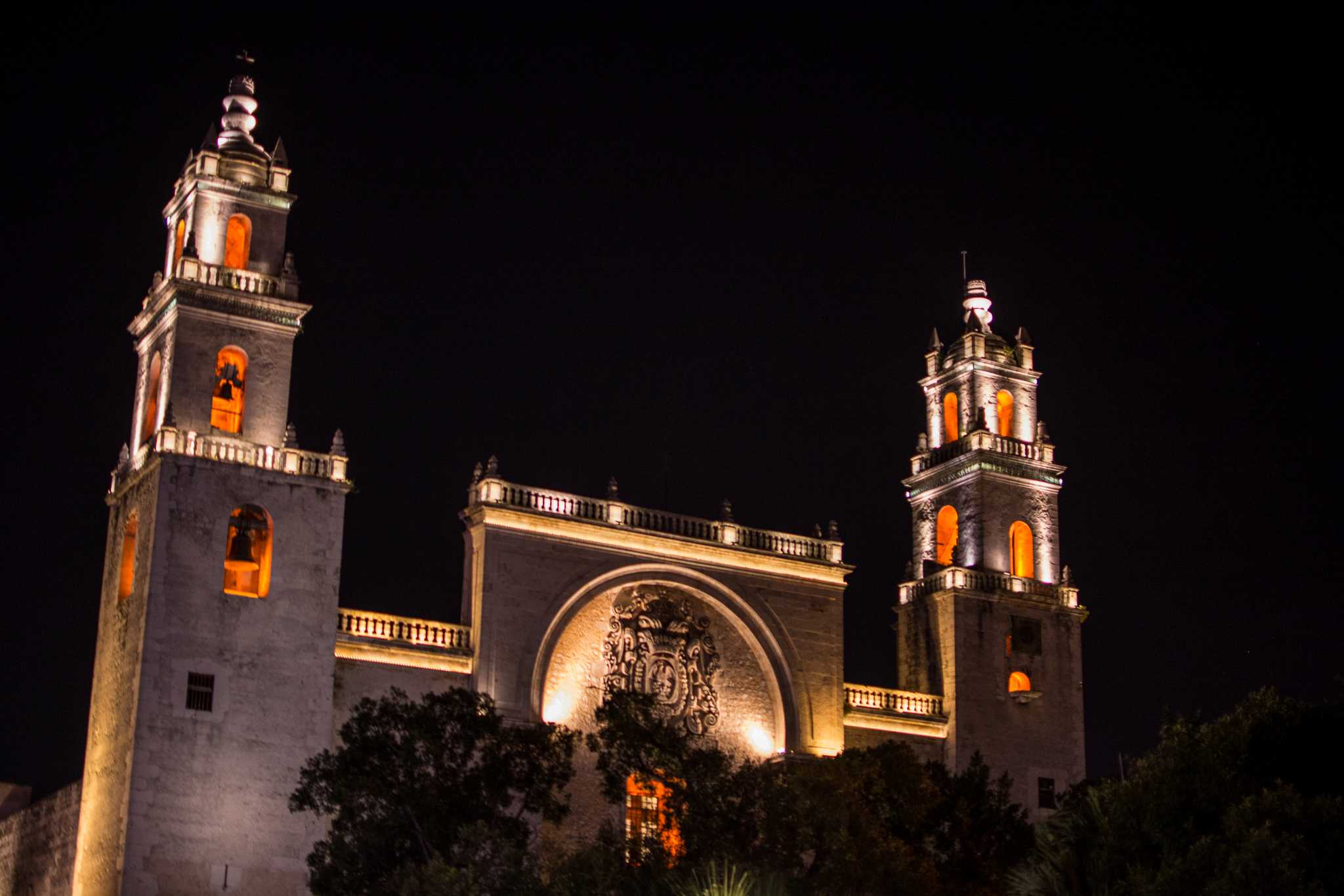 Merida’s cathedral lit up at night, its two towers glowing warmly.
