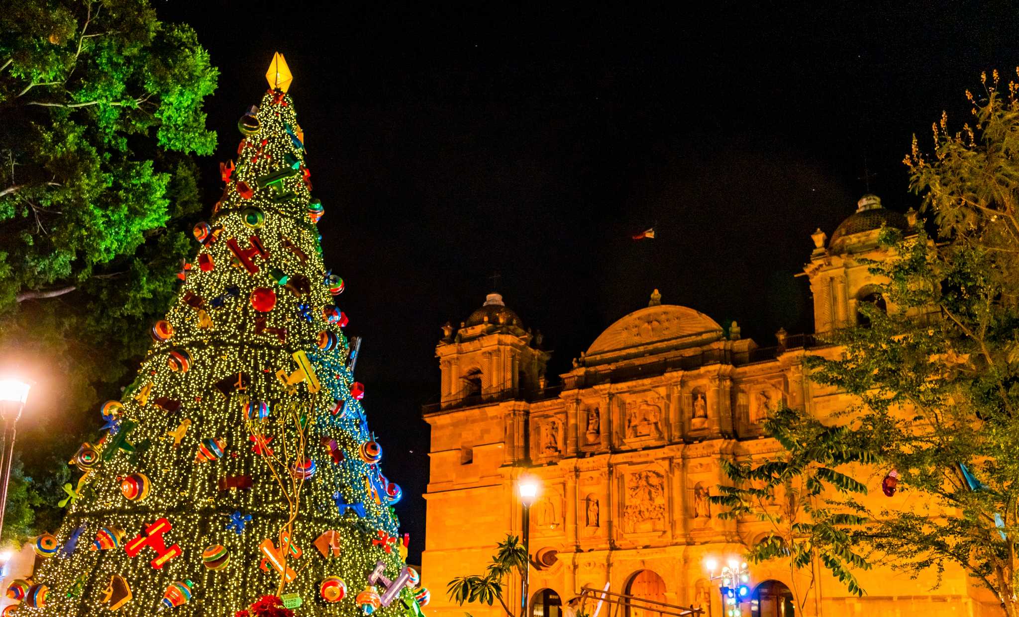 A lit christmas tree with colorful ornaments in front of Lady of Assumption Cathedral, Oaxaca, Mexico.