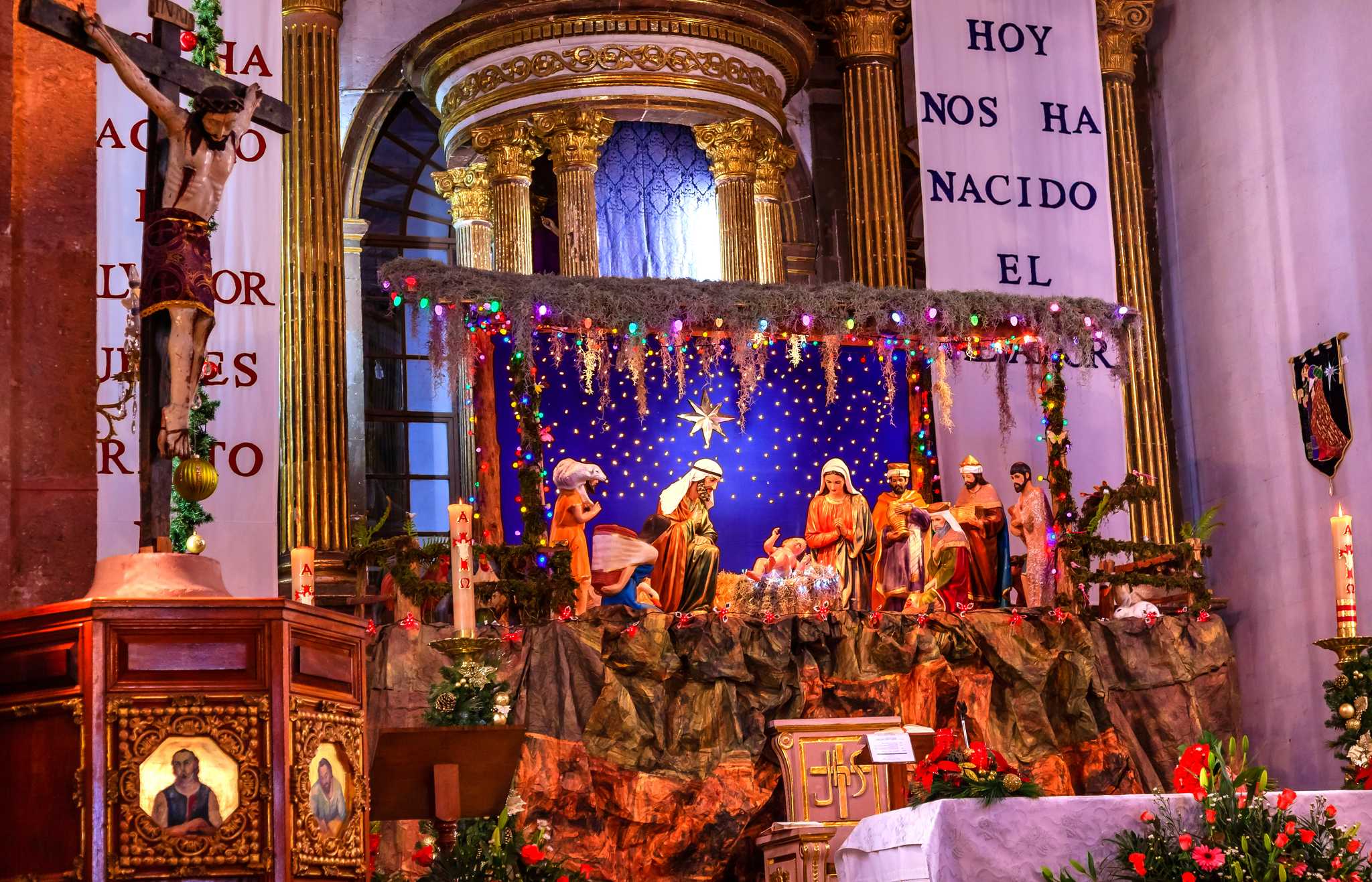 A warmly lit Christmas nativity scene at a church in San Miguel de Allende.