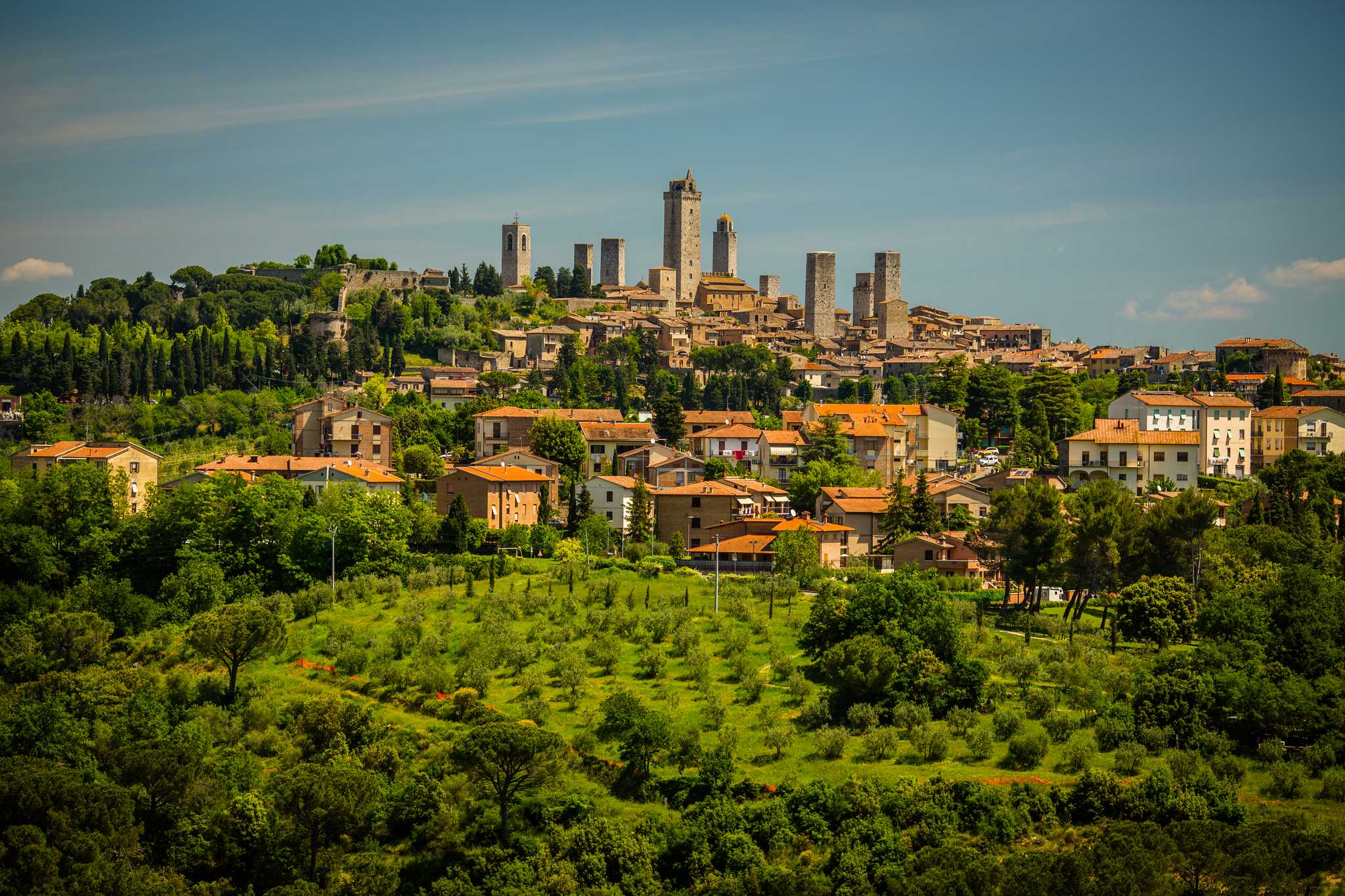 Montepulciano’s Medieval hilltown skyline of stone towers above green Tuscan hills.