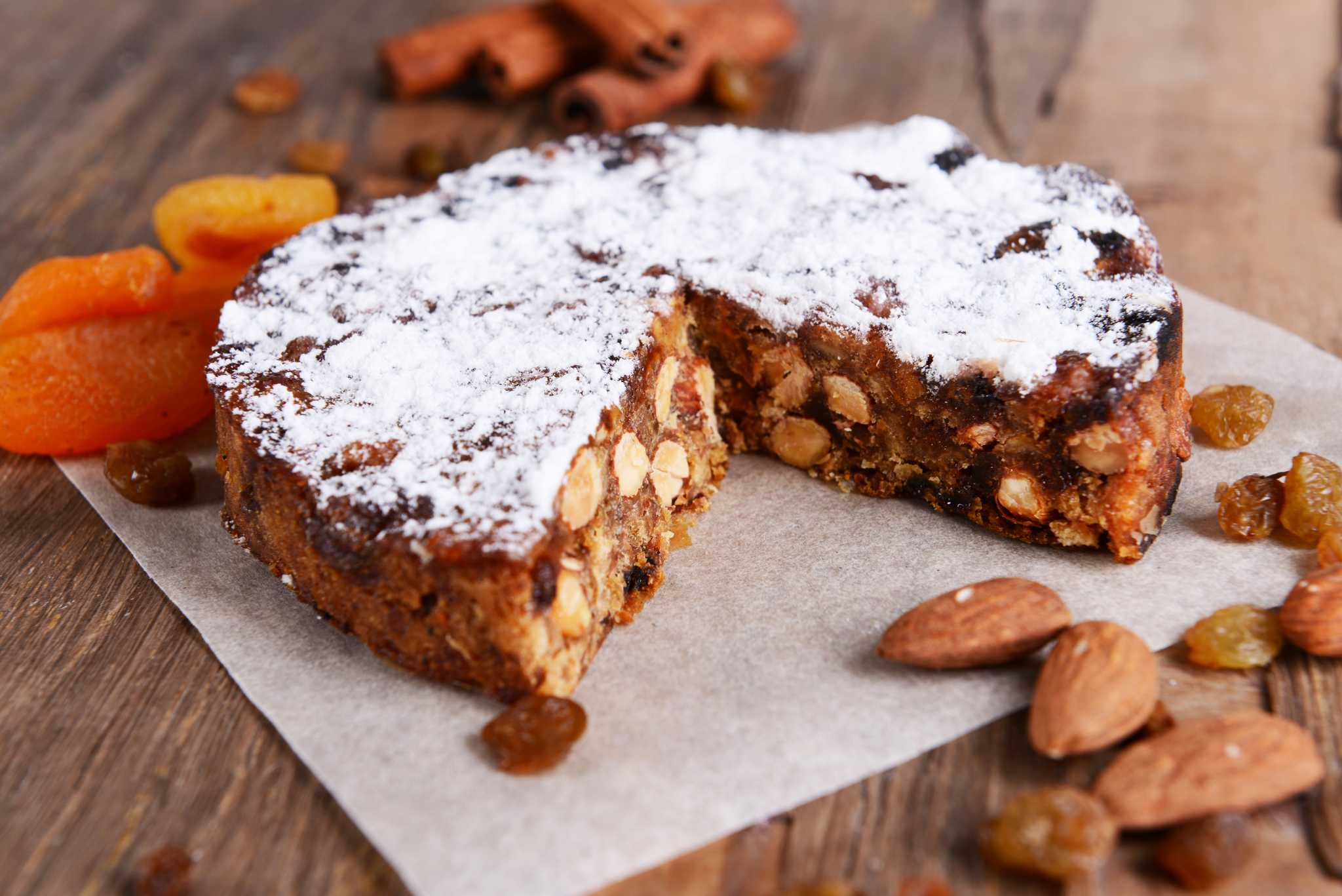 Panforte, an Italian cake common in Emilia-Romagna, served on a table and lightly dusted in powdered sugar.