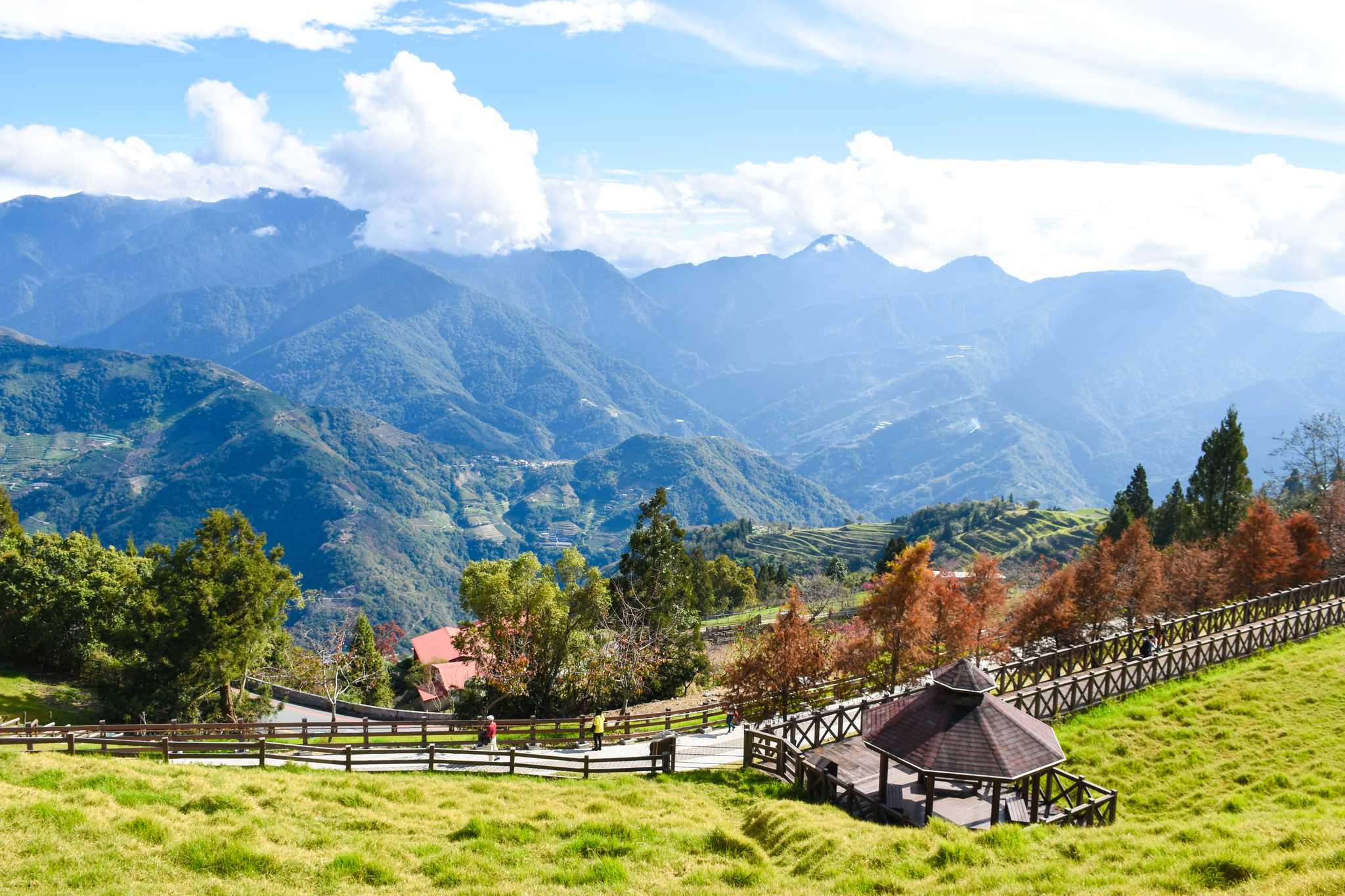 An open-air gazebo on a countryside road with the mountains in the background.