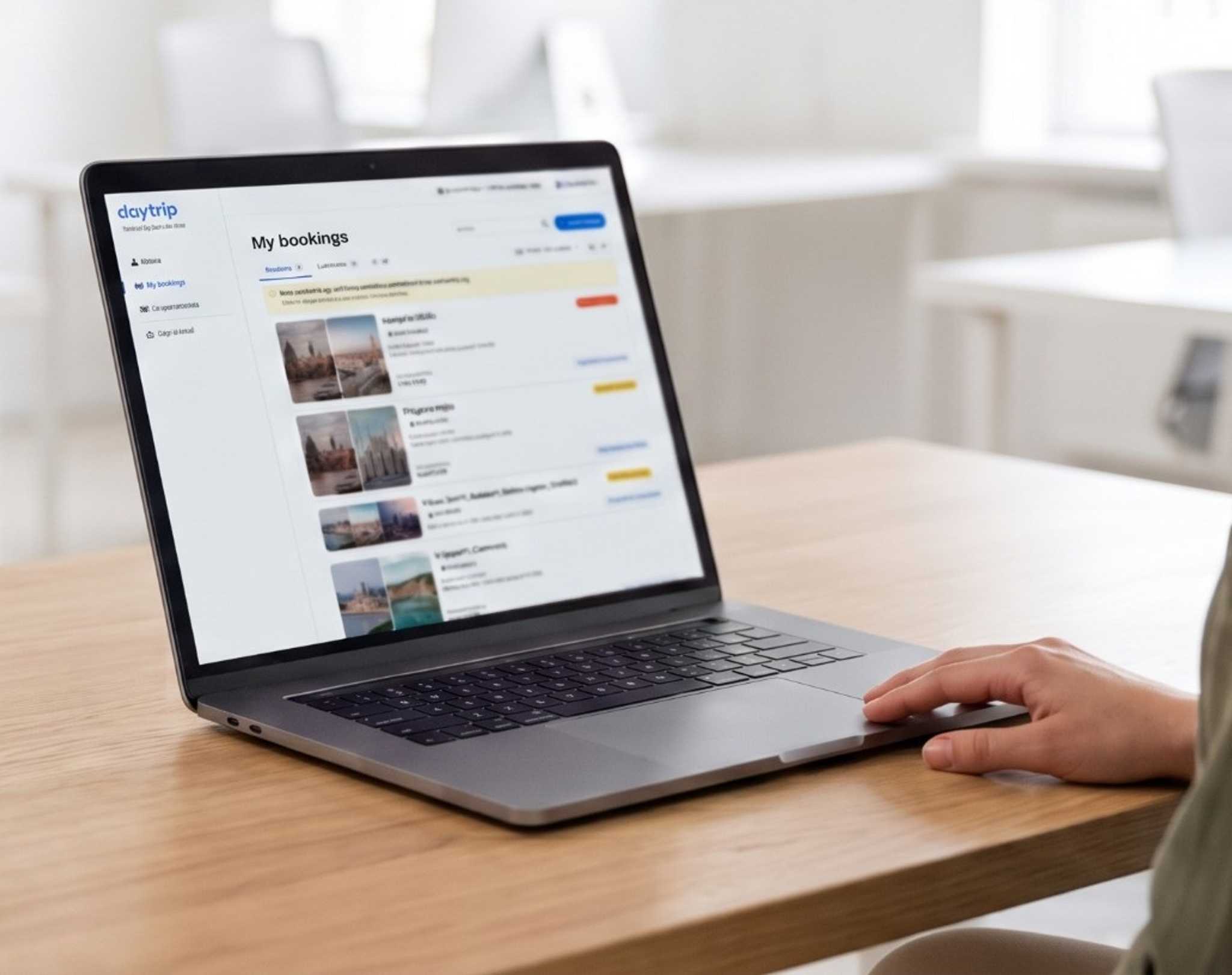 A travel agent at her desk with the Travel Agent Portal's My bookings page open on her laptop
