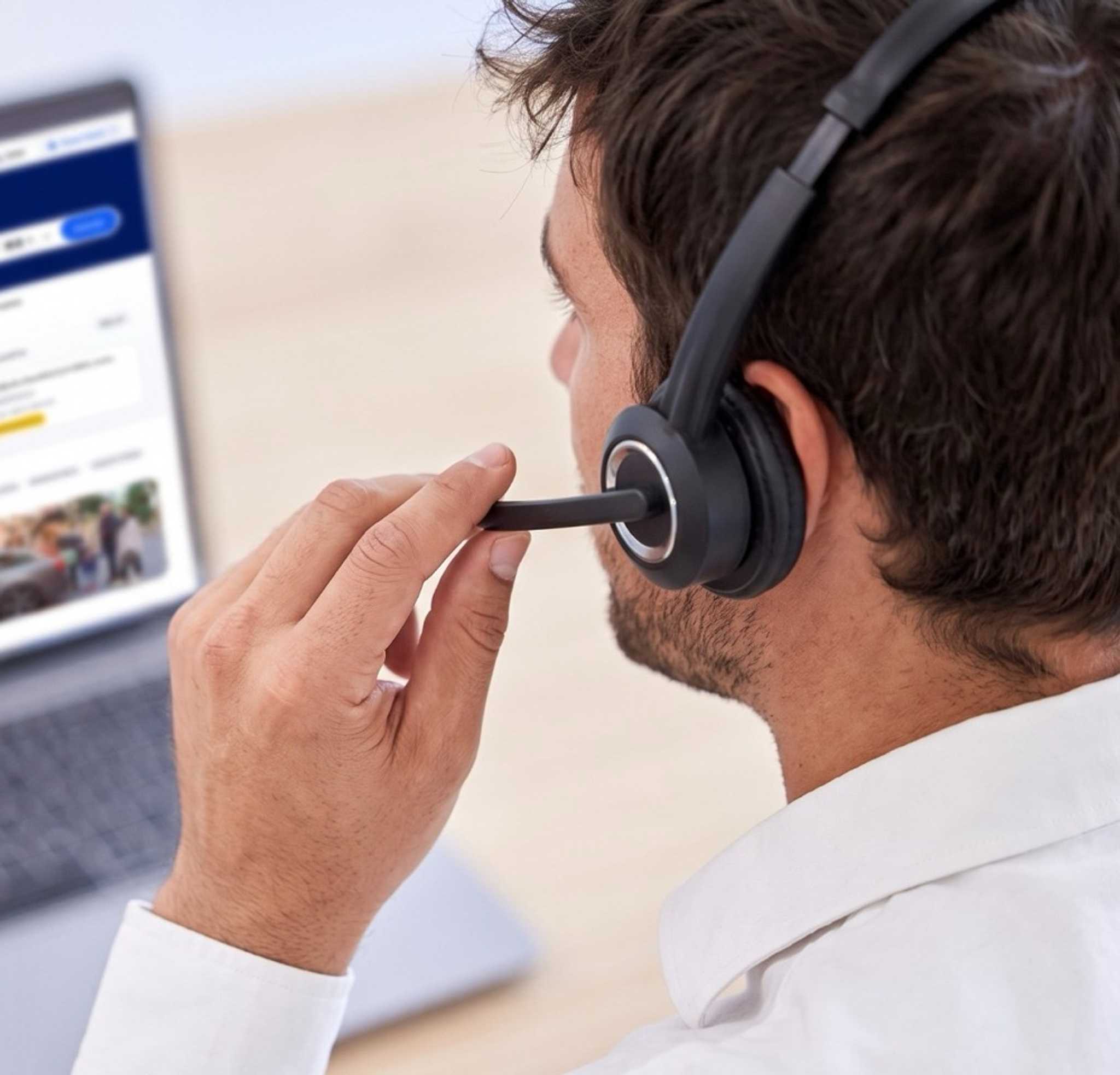 A Daytrip support agent in a headset on a call, with the Travel Agent Portal open on his laptop