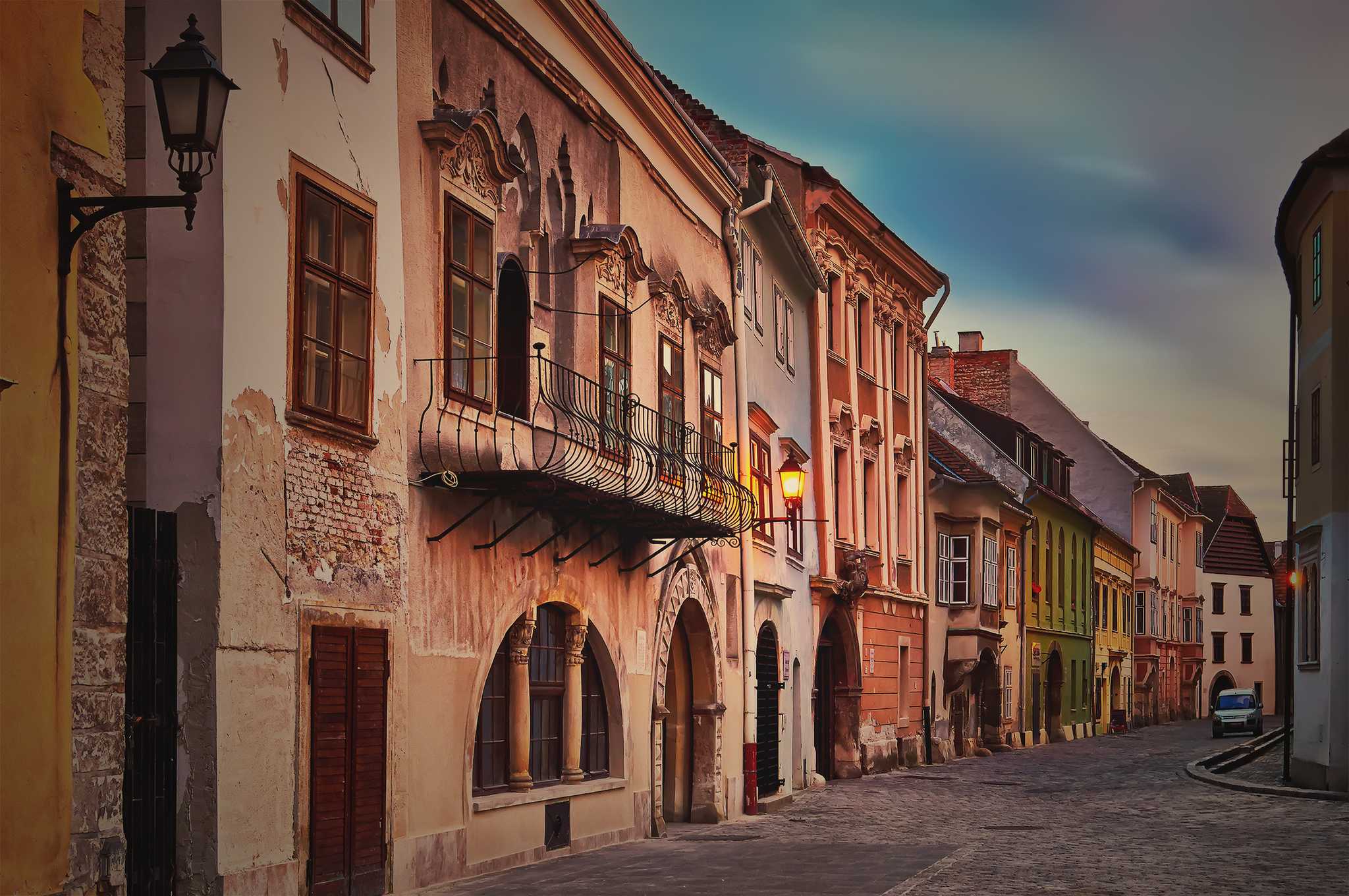 Empty cobbled street lined with weathered baroque townhouses in Sopron.