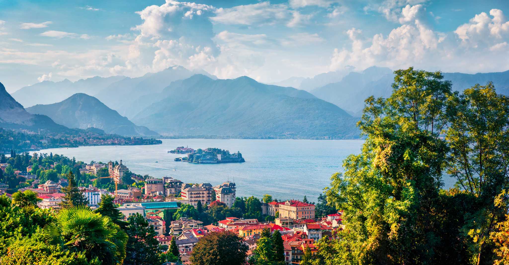 The lakeside town of Stresa as seen from above, with mountains in the background.