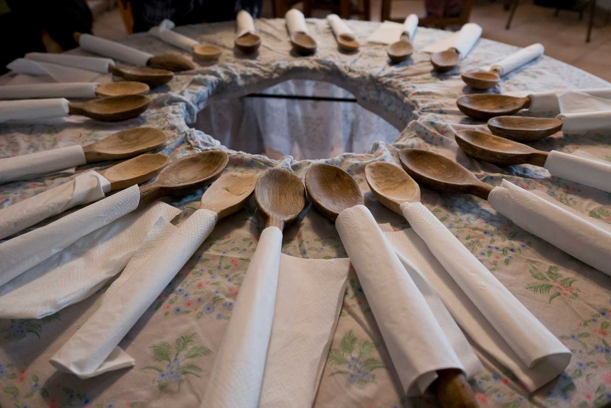 Wooden spoons laid out around a table for a communal meal of toc.