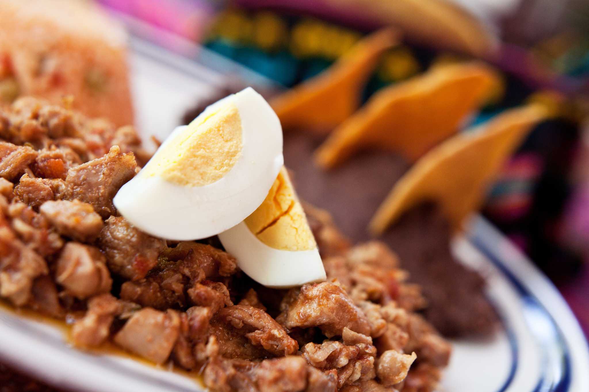 A close-up of a cooked turkey dish served with sliced egg on top.
