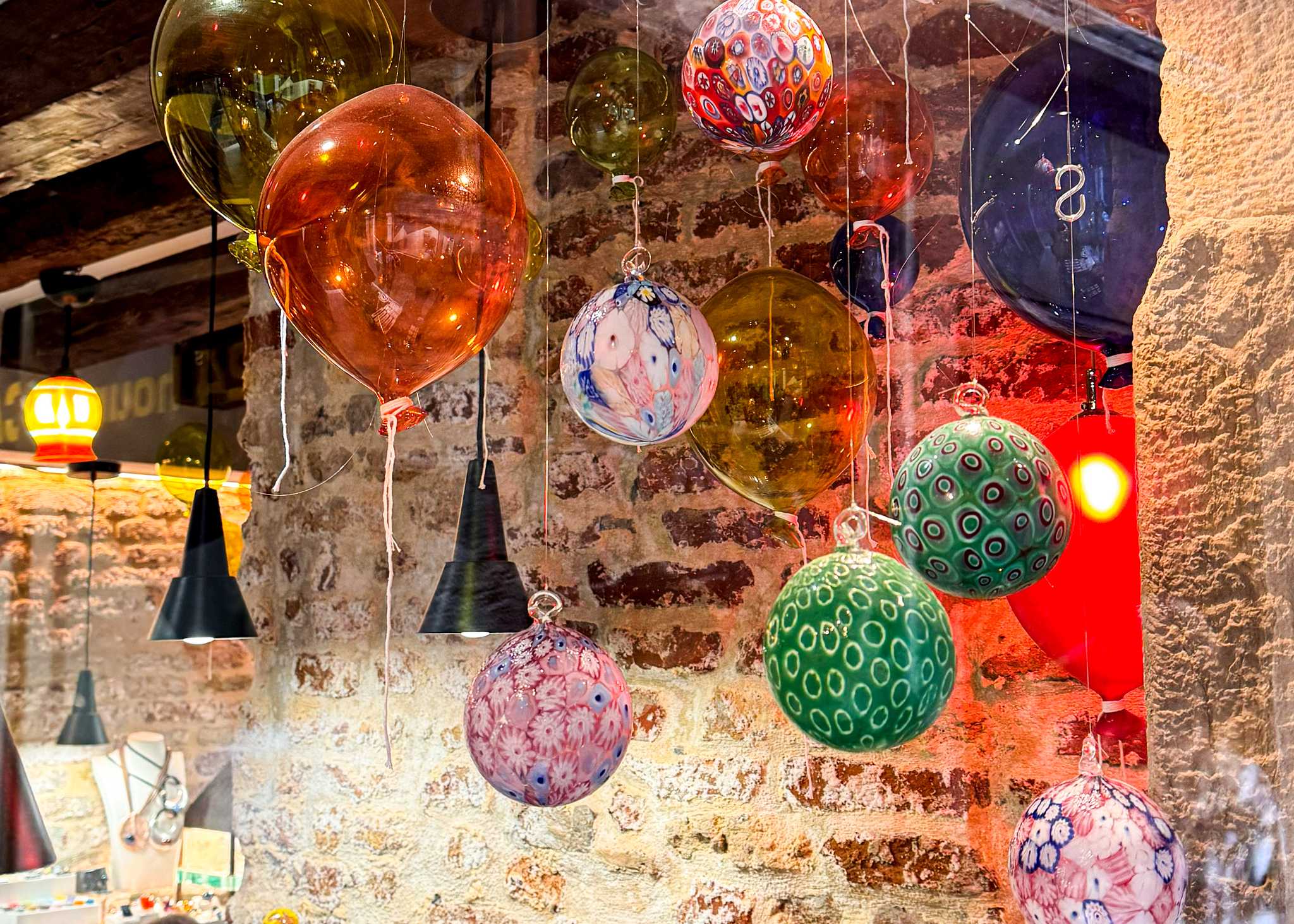 Colorful Venetian glass bulbs hang from the ceiling in a workshop studio in Murano.